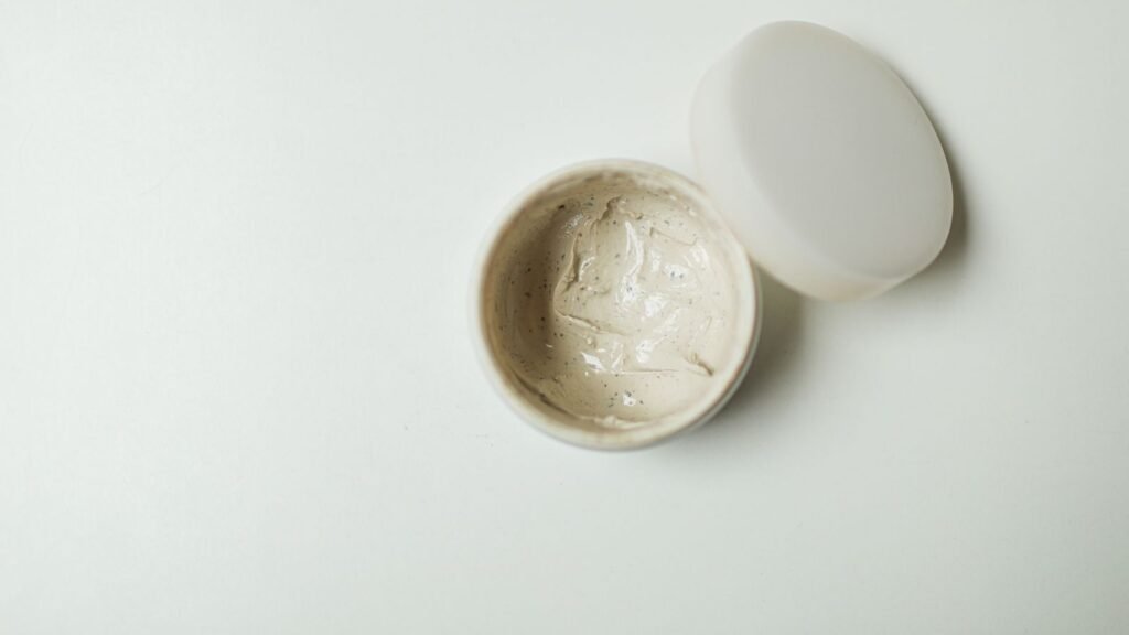 Opened cosmetic cream jar photographed from above