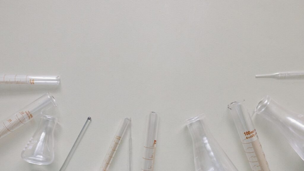 Flat lay of laboratory beakers and flasks on a neutral surface