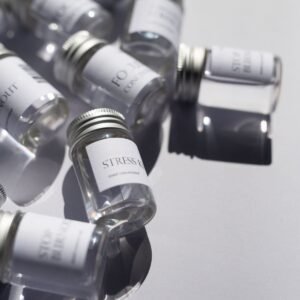 Labelled glass vials photographed on a reflective white surface